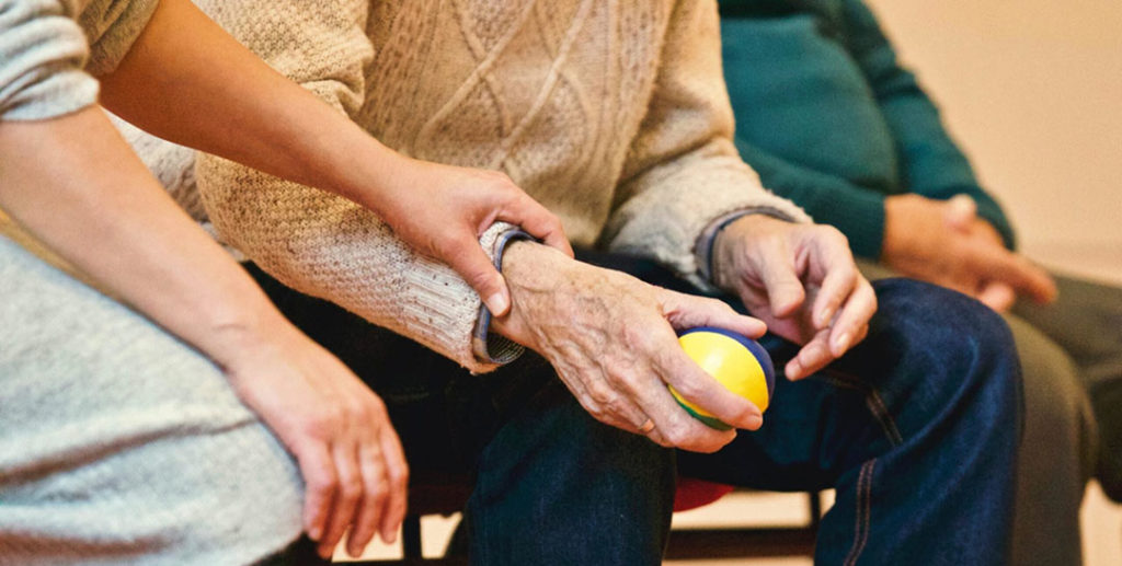 an in home caregiver helps a patient exercise