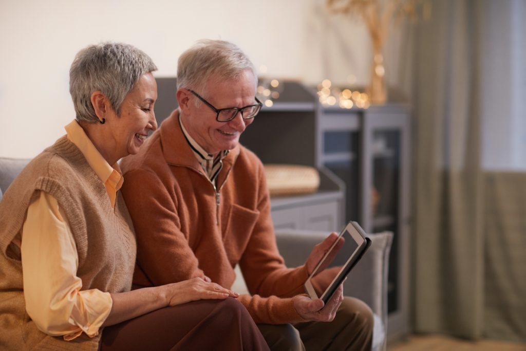 Two seniors reading together in a group home. 