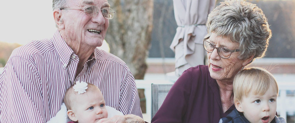 Two elderly people with their grandchildren at a long term care community. 